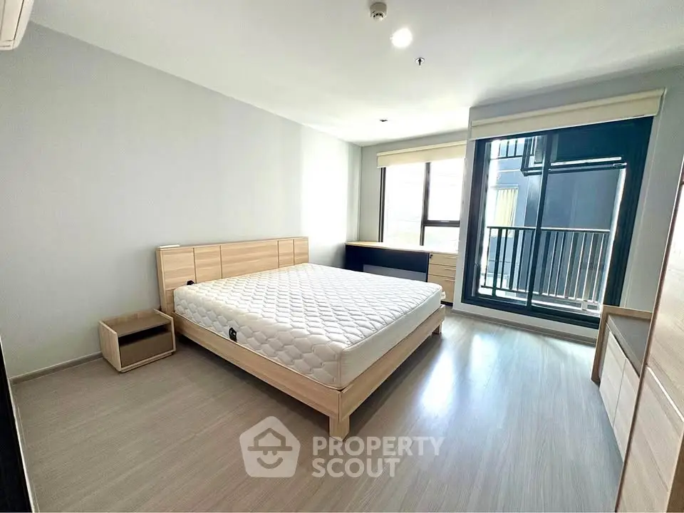 Spacious bedroom with modern design and large window offering natural light.