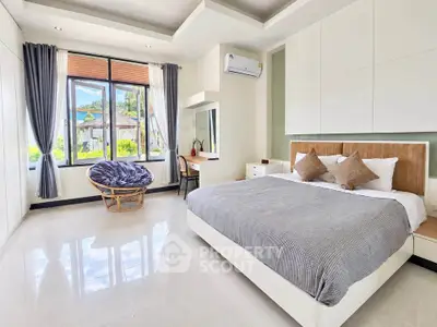 Spacious bedroom with modern decor and large windows offering scenic views.