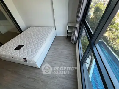 Modern bedroom with large windows and pool view, featuring a minimalist design and natural light.