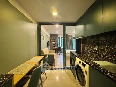 Modern apartment interior with open kitchen and cozy living area, featuring stylish furniture and appliances.
