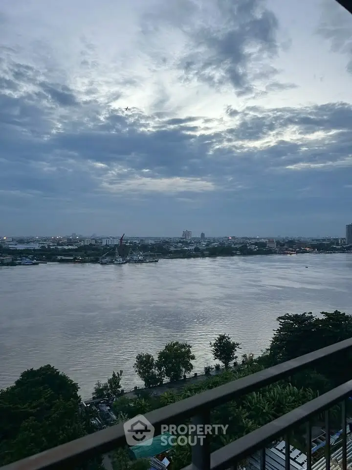 Stunning river view from a high-rise balcony at dusk, perfect for serene living.