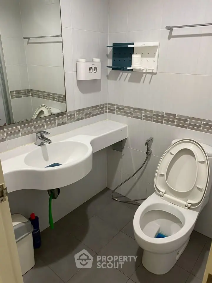 Modern bathroom with sleek fixtures and contemporary design, featuring a wall-mounted sink and toilet.