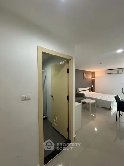 Modern studio apartment with sleek design and open layout, featuring a cozy living area and compact bathroom.
