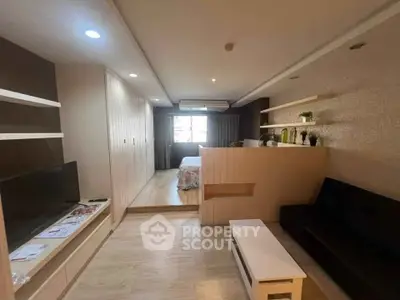 Modern studio apartment with stylish decor and open layout, featuring a cozy living area and bedroom.