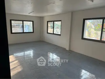 Spacious unfurnished room with large windows and tiled flooring, perfect for customization.