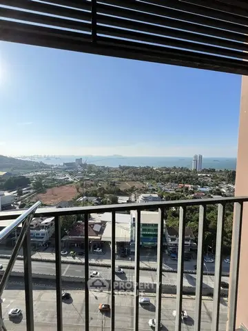 Stunning high-rise balcony view overlooking cityscape and ocean horizon.