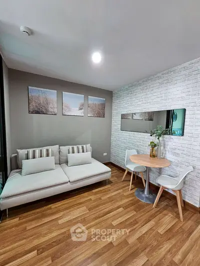 Modern living room with cozy sofa and dining area, featuring stylish decor and wooden flooring.