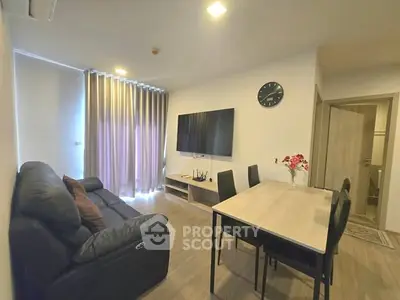 Modern living room with sleek furniture and large TV, perfect for relaxation and entertainment.