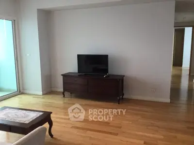 Spacious living room with wooden flooring and modern TV setup