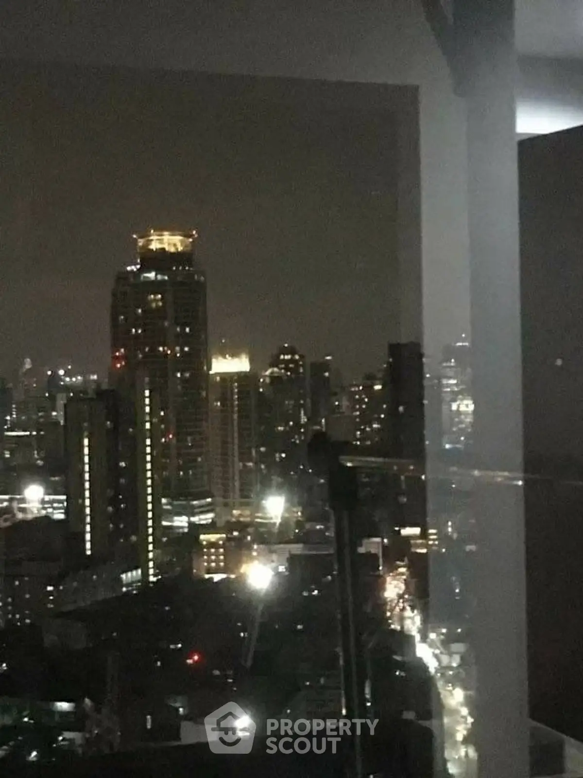 Stunning night cityscape view from a high-rise balcony, showcasing vibrant urban lights.