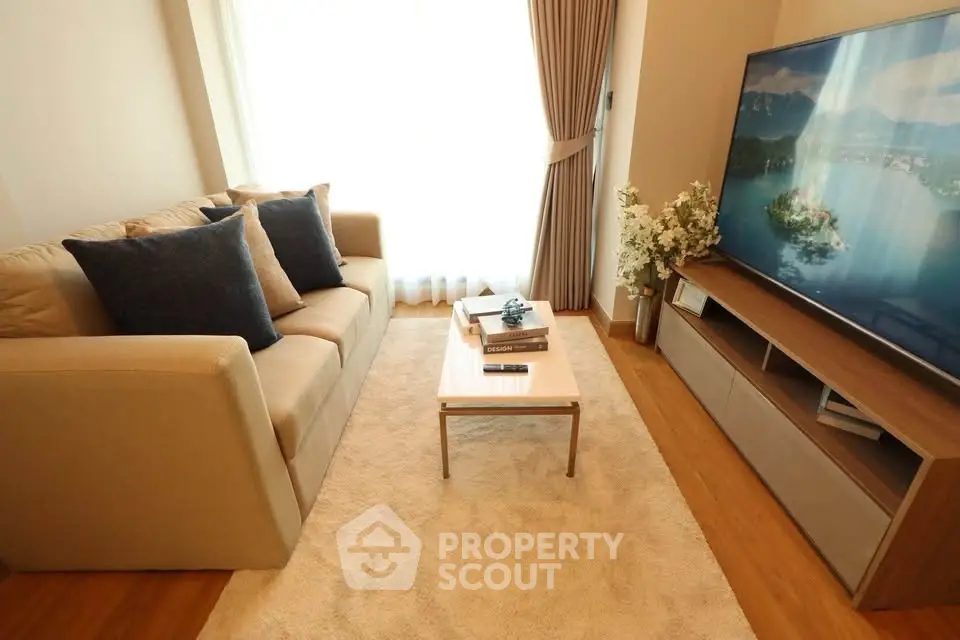 Cozy living room with modern sofa and large TV, perfect for relaxation.
