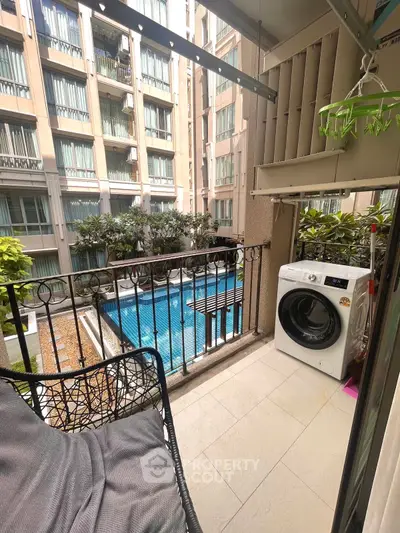 Charming balcony with pool view and washing machine in modern apartment