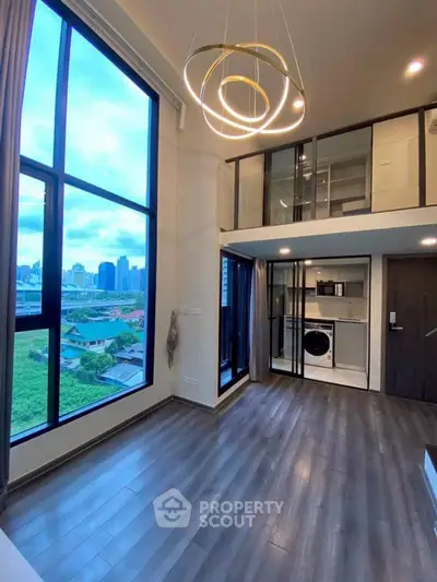 Modern loft apartment with floor-to-ceiling windows and stylish lighting in urban setting.