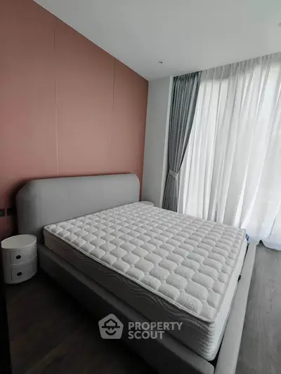 Modern bedroom with stylish bed and floor-to-ceiling curtains in a chic apartment.