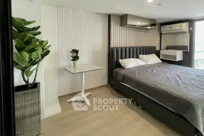 Modern bedroom with stylish decor and natural light, featuring a cozy bed and elegant furnishings.