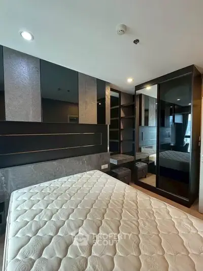 Modern bedroom with stylish decor and large mirrored wardrobe