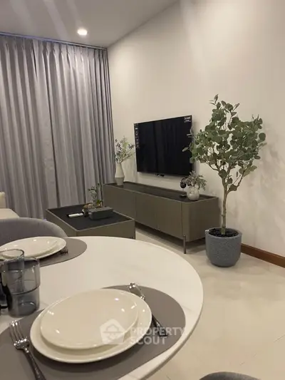 Modern living room with sleek TV setup and elegant dining area