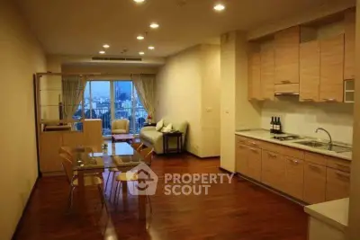 Spacious open-plan living and dining area with city view, modern kitchen, and elegant wooden flooring.
