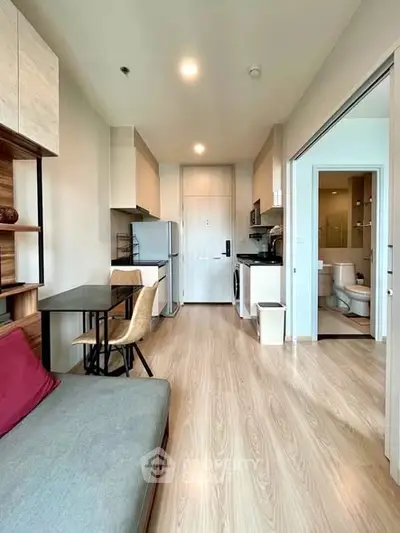 Modern apartment interior with open layout, featuring kitchen and living area with sleek design.