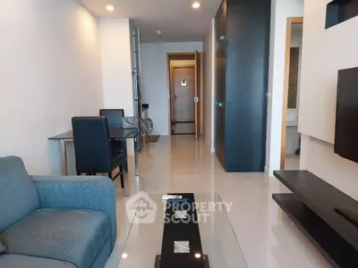 Modern living room with sleek furniture and open layout, featuring a stylish sofa and wall-mounted TV.