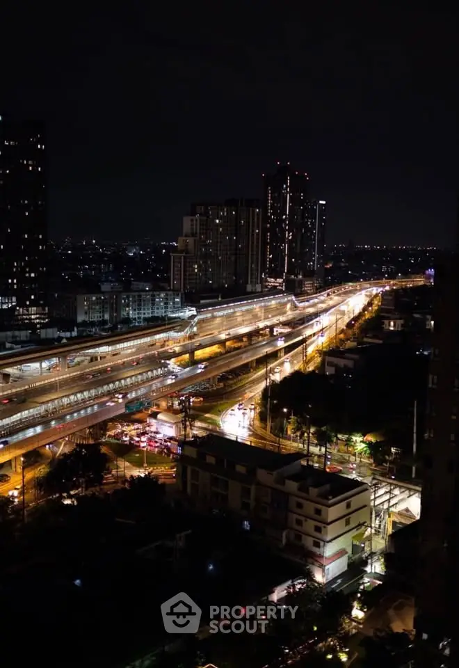 Stunning night cityscape view with illuminated roads and high-rise buildings.