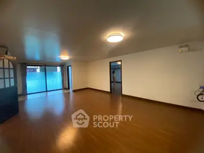 Spacious living room with wooden flooring and large windows for natural light