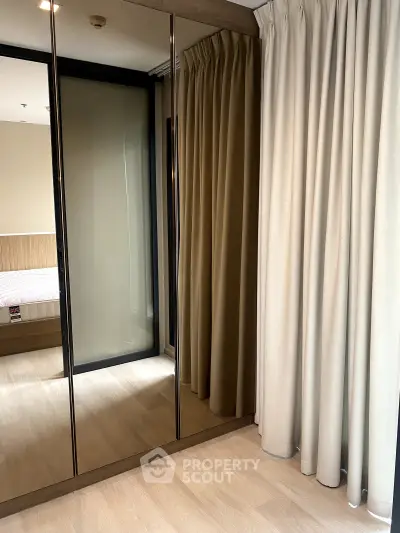 Modern bedroom with mirrored wardrobe and elegant curtains