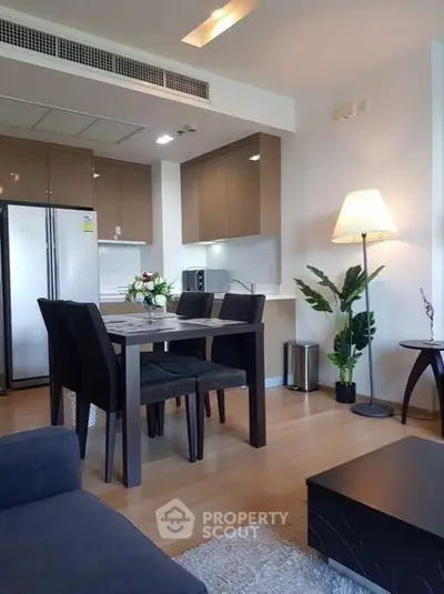 Modern open-layout kitchen and dining area with stylish decor and natural lighting.