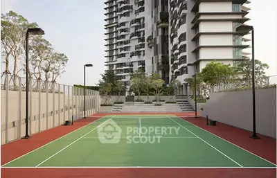 Modern residential building with tennis court and landscaped surroundings.