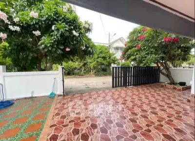 Charming outdoor patio with vibrant garden view and tiled flooring.