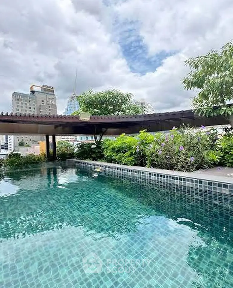 Luxurious rooftop pool with city skyline views and lush greenery.