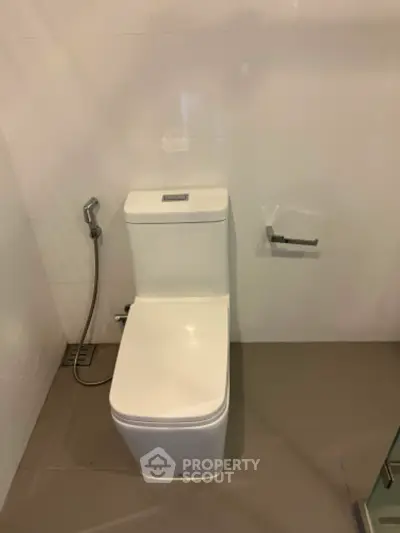 Modern bathroom with sleek white toilet and bidet spray