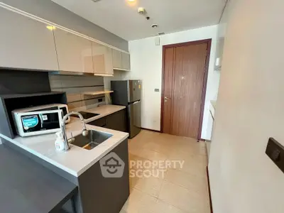 Modern kitchen with sleek cabinetry, stainless steel appliances, and compact design in a contemporary apartment.