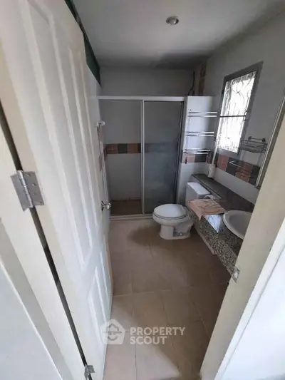 Modern bathroom with shower and toilet in a cozy home setting.