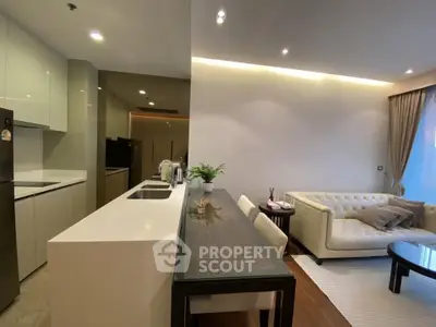 Modern open-layout living room and kitchen with sleek design and elegant furnishings.