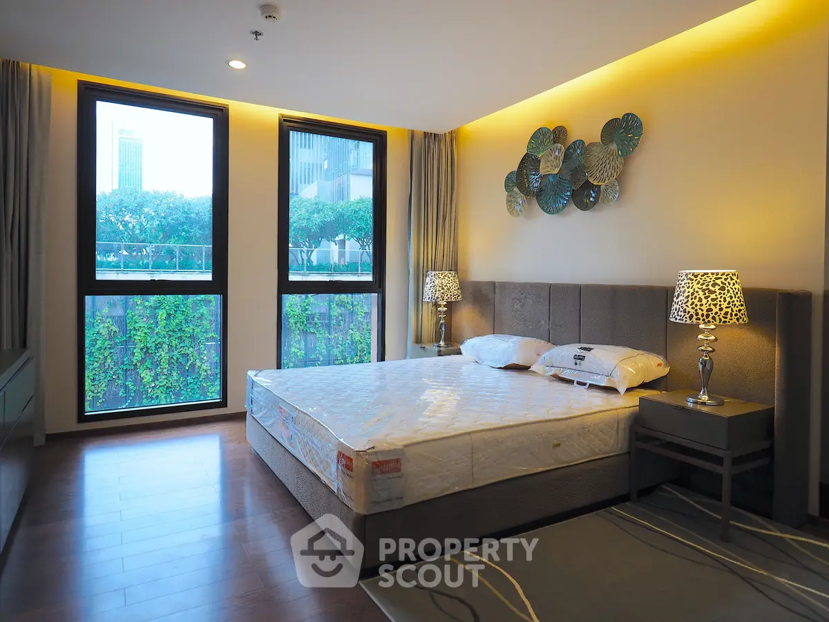Luxurious bedroom with modern decor and large windows offering a serene view, perfect for relaxation.