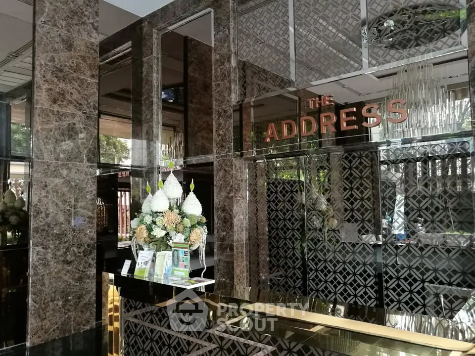 Luxurious building entrance with elegant marble decor and floral arrangement
