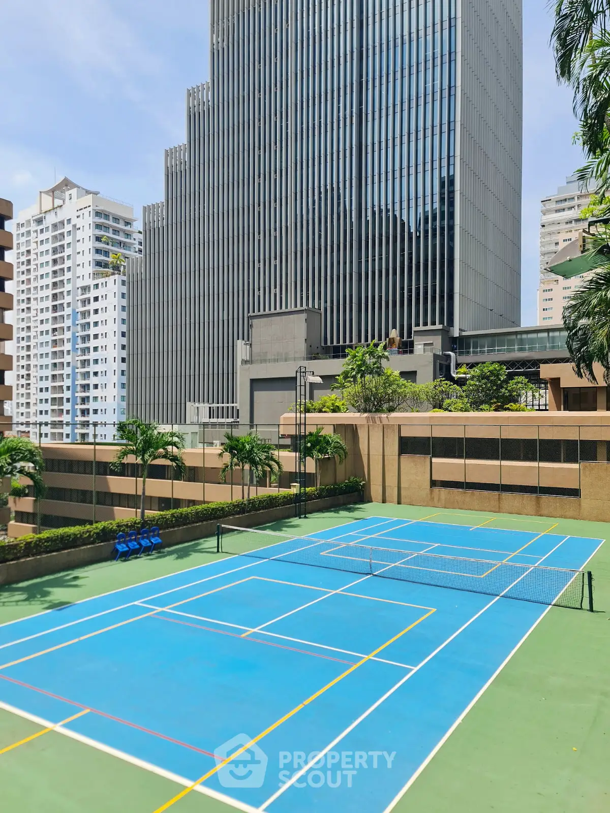 Luxurious urban tennis court with stunning skyscraper backdrop, perfect for city living enthusiasts.