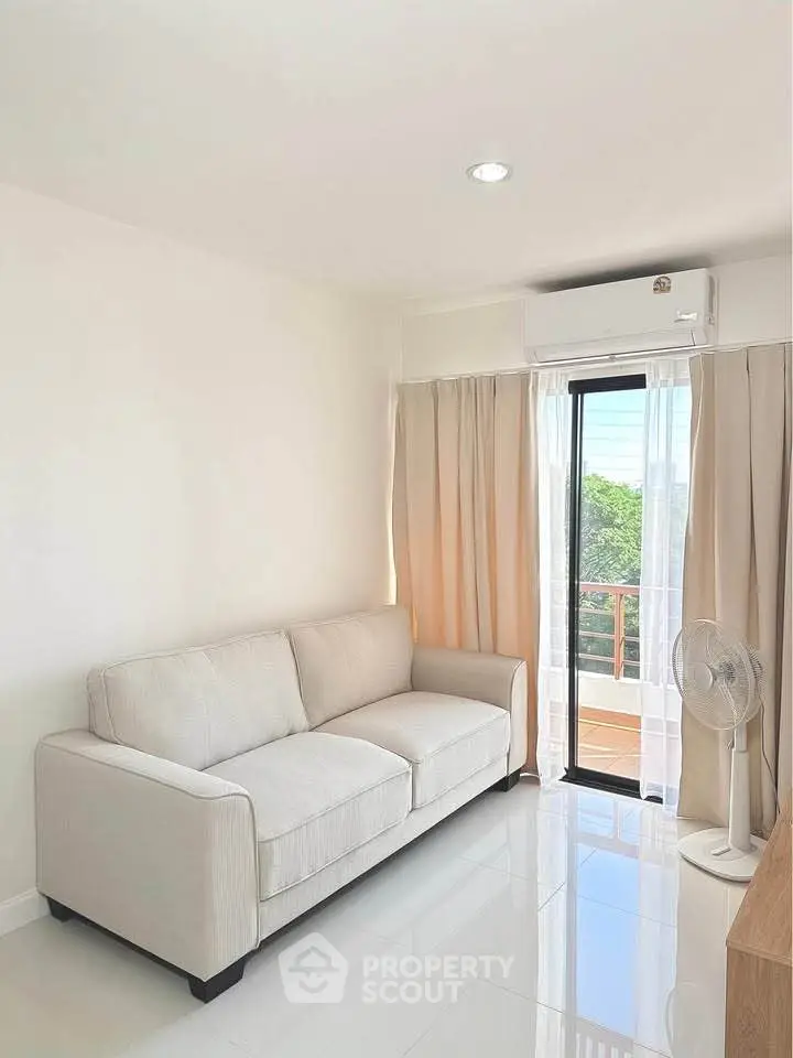 Bright living room with cozy sofa and balcony view