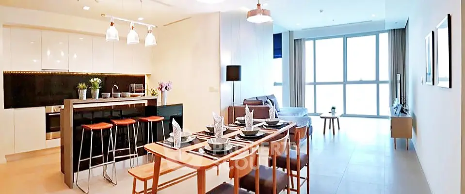Spacious modern living room with open kitchen and dining area, featuring sleek design and ample natural light.