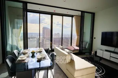 Luxurious high-rise living room with stunning city view, modern furniture, and elegant dining area.
