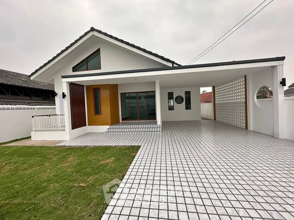 Modern single-story house with spacious driveway and green lawn