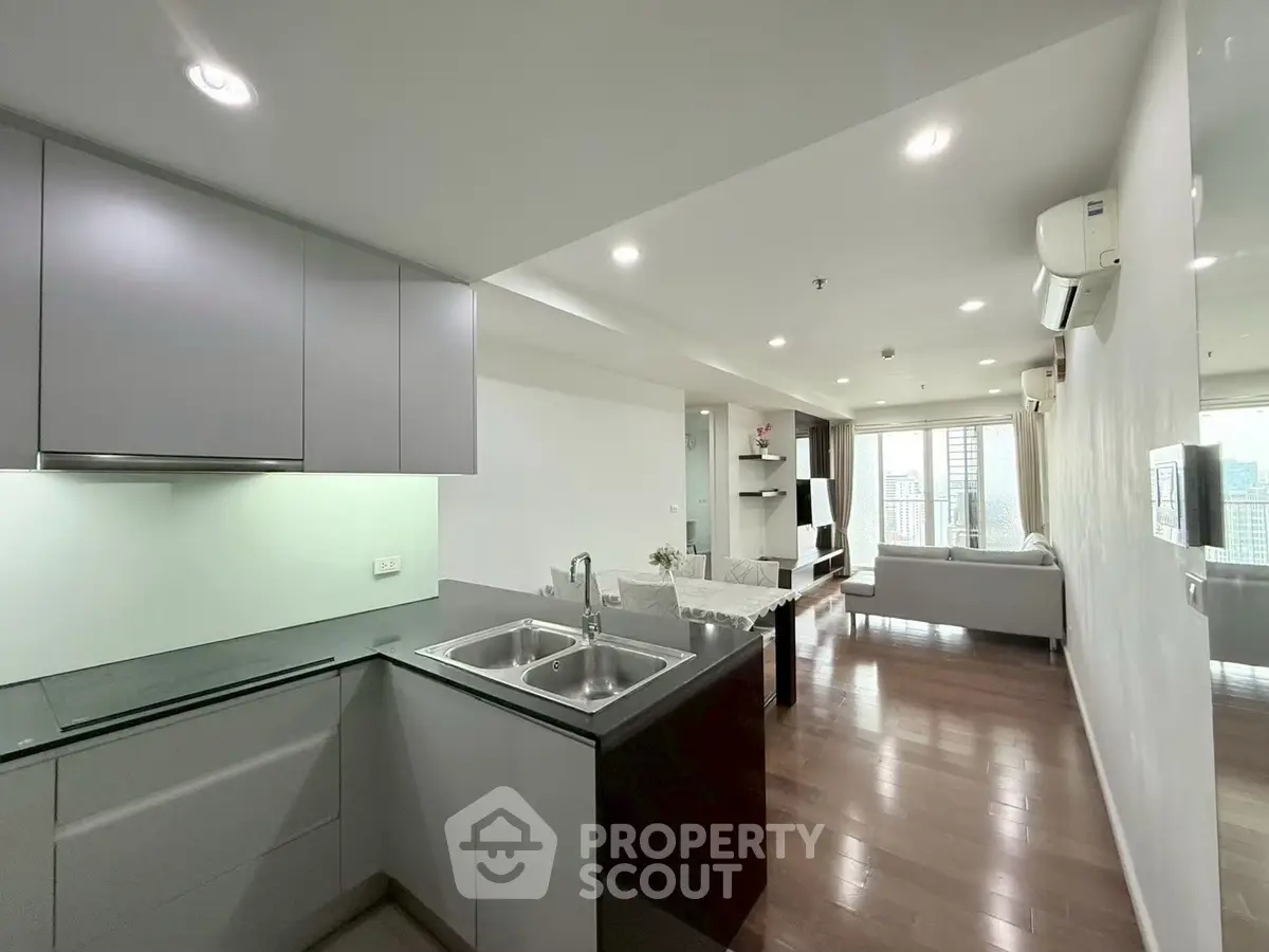 Modern open-plan living room with sleek kitchen and city view