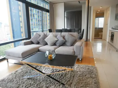 Modern living room with city view, stylish furniture, and open layout in high-rise apartment.
