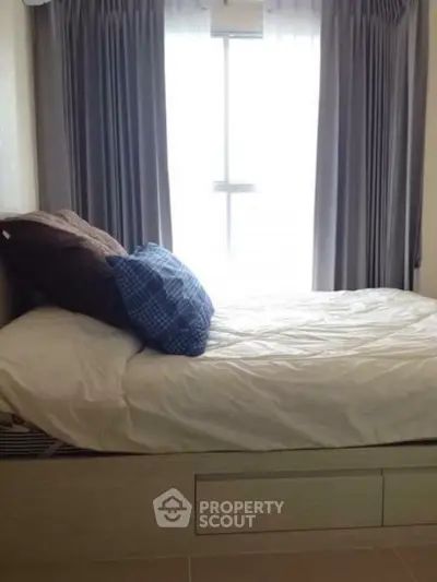 Cozy bedroom with natural light and stylish curtains, perfect for relaxation.