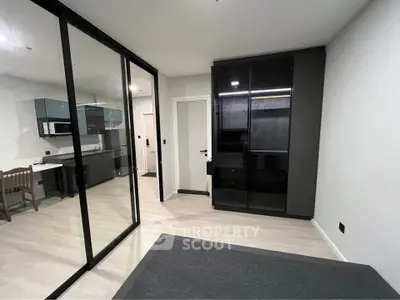 Modern apartment interior with sleek glass partitions and stylish kitchen area.