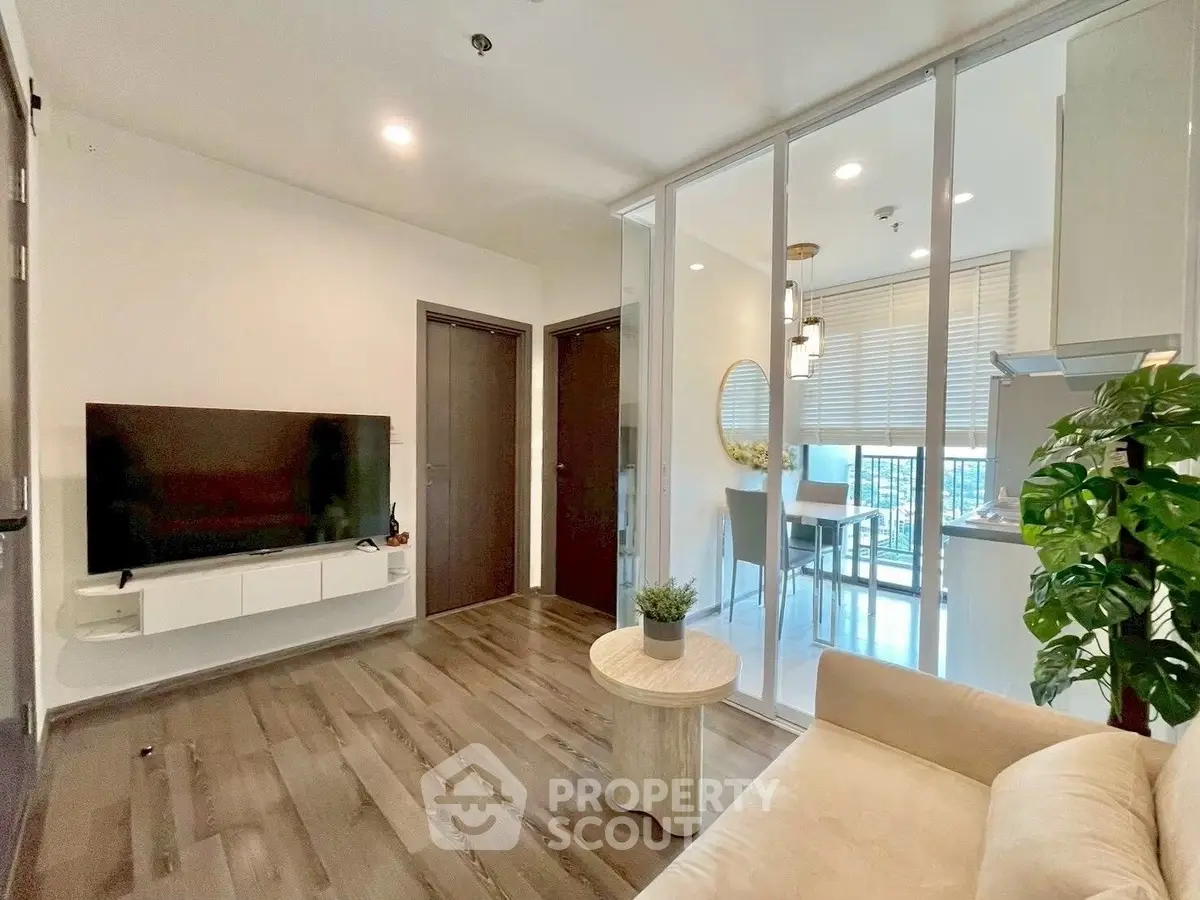 Modern living room with sleek design and open layout, featuring a wall-mounted TV and stylish decor.