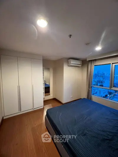 Modern bedroom with city view and sleek wooden flooring