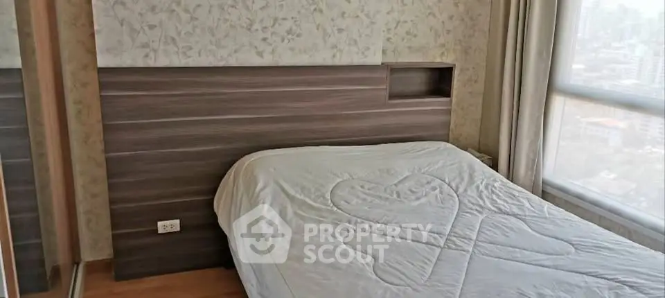Cozy bedroom with elegant wood paneling and large window offering city views.