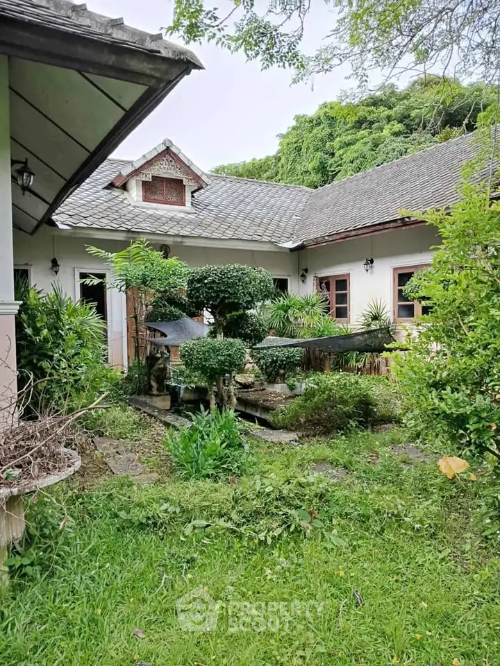 Charming garden view of a rustic house with lush greenery and traditional architecture.